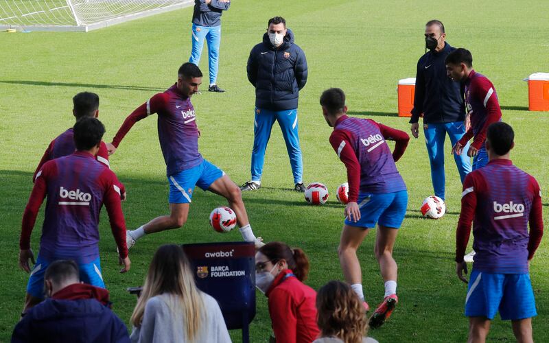 Barcelona manager Xavi looks on as Ferran Torres trains with teammates at Camp Nou. Reuters