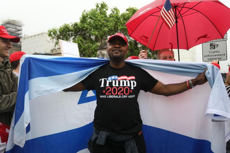 A Trump supporter is wrapped in an Israeli flag as they counter a demonstration against the state visit in central London on June 4, 2019. AFP