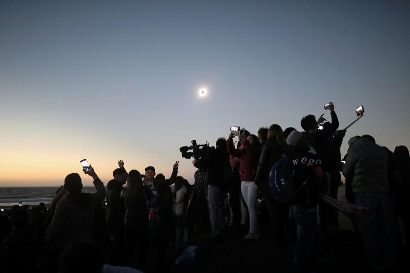 People watch a solar eclipse at La Serena, Chile. Reuters