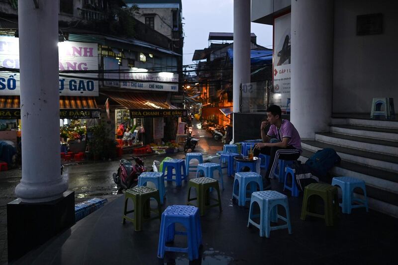 This picture taken on March 23, 2020 shows a man sitting alone at a street-cafe, amid concerns over the spread of the COVID-19 novel coronavirus, in Hanoi. / AFP / Manan VATSYAYANA

