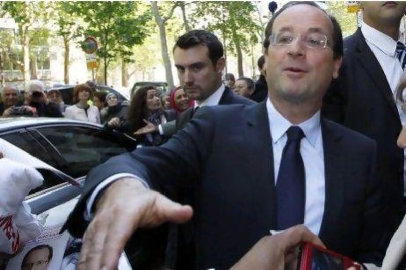 The newly-elected French president, Francois Hollande, shakes hands with supporters as he arrives at his former campaign headquarters in Paris yesterday.