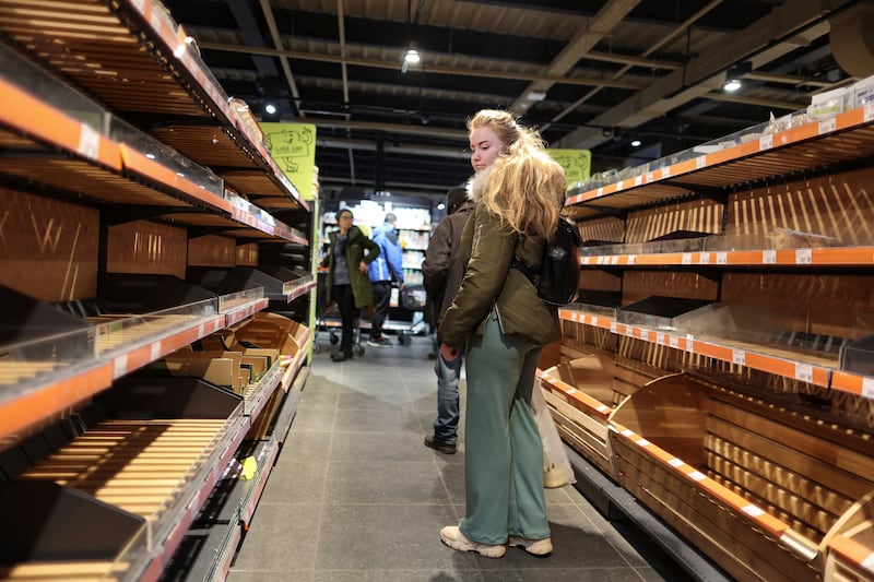 A woman in Kyiv looks at empty supermarket shelves after the curfew was lifted on February 28. Reuters