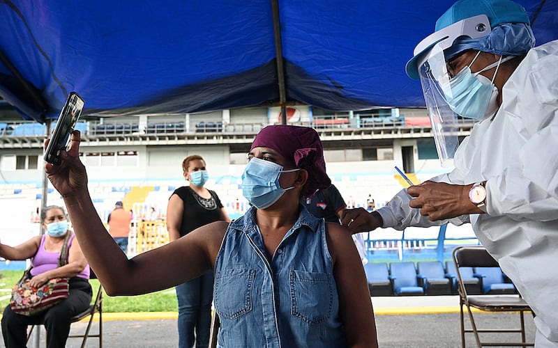 A woman takes a selfie while receiving the first dose of the Moderna vaccine against Covid-19, during the vaccination day called 'Vacunaton', which aims to immunise 50,000 Hondurans aged over 35 in the National Stadium, in Tegucigalpa.