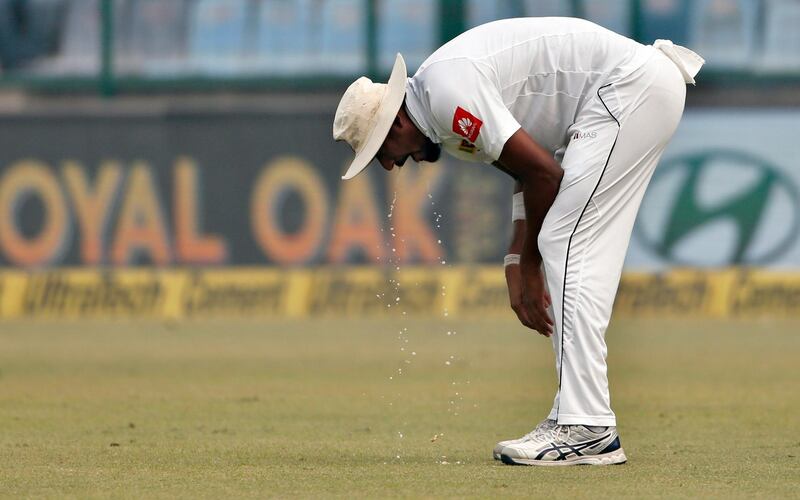 Sri Lanka's Suranga Lakmal vomits during the fourth day of their third test cricket match against India in New Delhi. Altaf Qadri / AP Photo