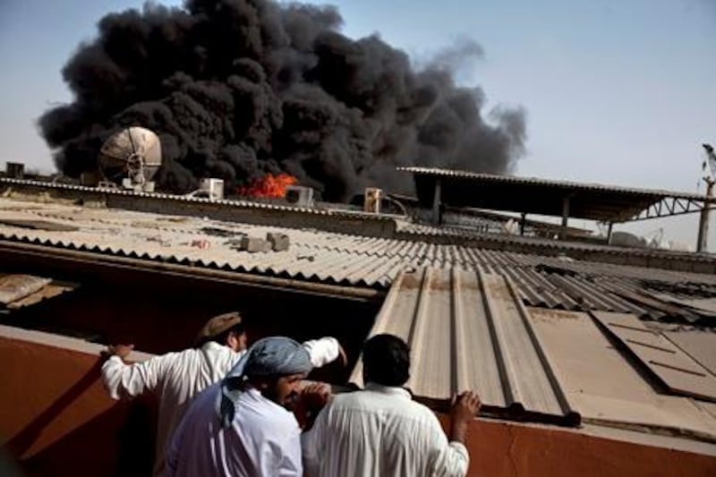 Abu Dhabi, United Arab Emirates, July 19, 2013  :  People look on as thick black smoke rises from a diesel tanker truck, which caught fire around 12:30pm on Friday, July 19, 2013, while parked next another diesel truck in a labor camp area (Sector 37) near the ICAD Residential City in Mussafah, an industrial section of Abu Dhabi. 
Silvia Razgova / The National

Project: reporter Ola


