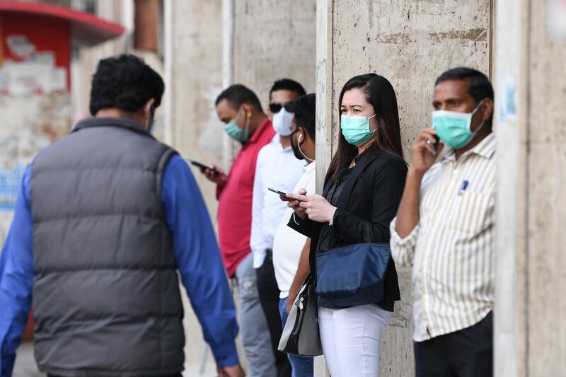 People wearing protective face masks in a street in Kuwait City, Kuwait.  EPA