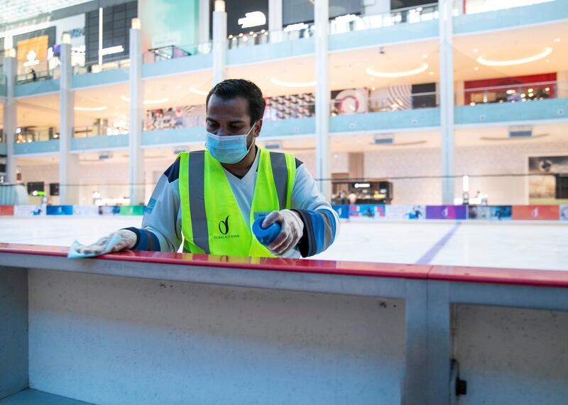 DUBAI, UNITED ARAB EMIRATES. 11 JUNE 2020. 
Babki sanitizes the railing at the Ice Rink in Dubai Mall.
(Photo: Reem Mohammed/The National)

Reporter:
Section: