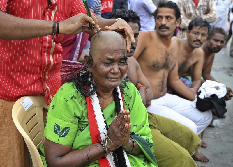 A supporter of India's popular politician and former film actress, Jayaram Jayalalithaa, weeps as she gets her head shaved to mourn the death of the leader in Chennai, India on December 7, 2016. Aijaz Rahi/AP Photo