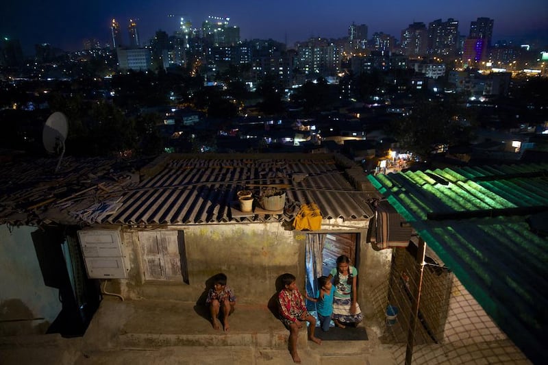 A slum in Mumbai. Prayaag Akbar, below, sets his debut in the future city of Purity One, a world of elitist gated communities, poverty, vigilante thugs and re-education camps, based on present-day Indian society. Gianluca Colla / National Geographic / Getty Images; Simon and Schuster