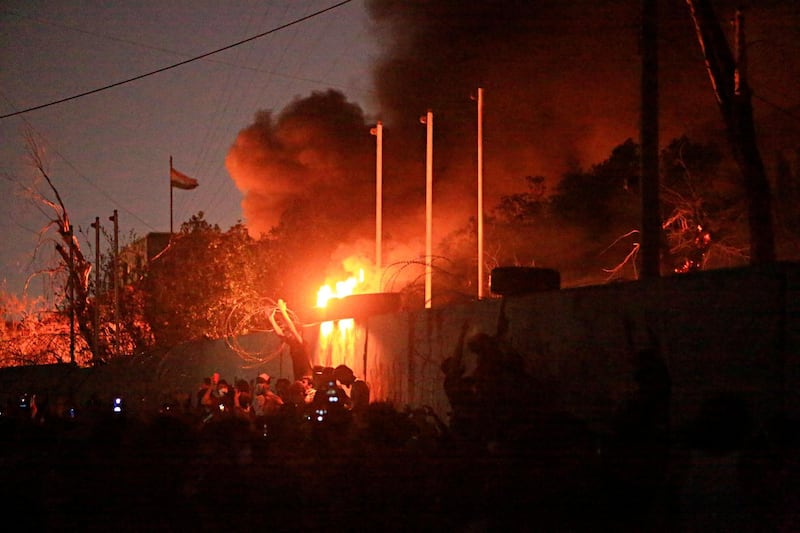 People burn the governor's building during protests in Basra. AP Photo