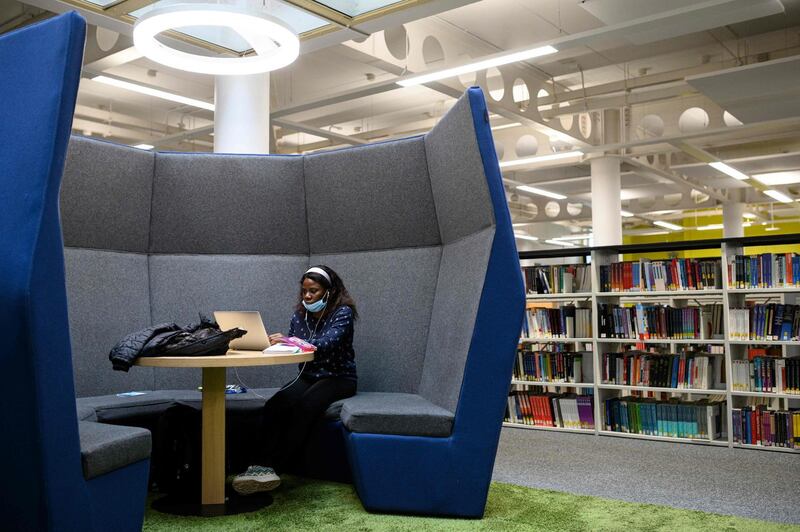 A student studies in Coventry University Library whilst observing social distancing regulations. AFP