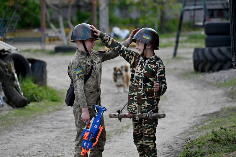 Ukrainian boys play at being soldiers in the village of Stoyanka. AFP
