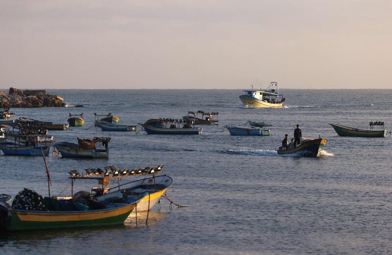 A Palestinian boat returns to port past idle vessels moored at Gaza City's main fishing harbour. AFP