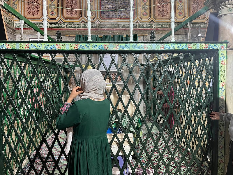 A Tunisian woman stands in front of the Sidi Sahbi shrine to read Fatiha and pray