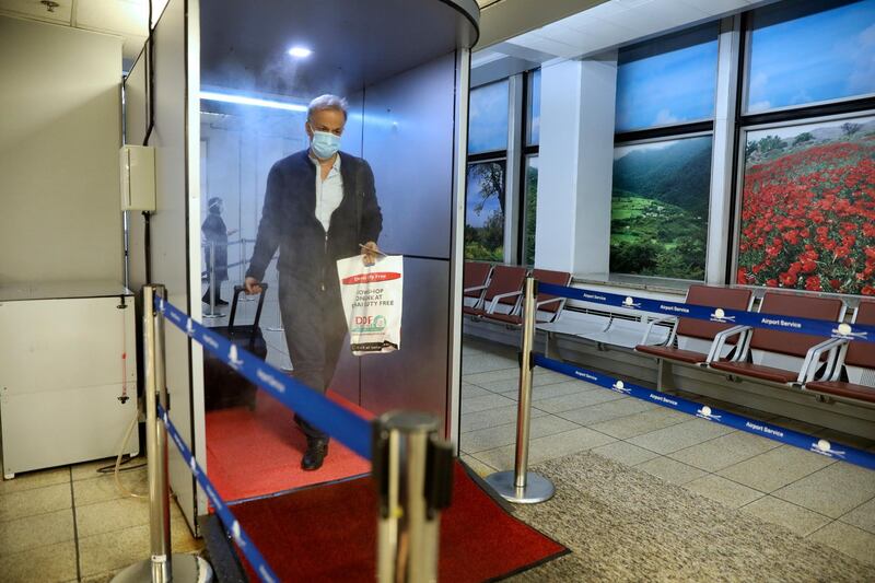 An Emirates passenger walks through a disinfectant tunnel to help prevent the spread of the coronavirus upon arrival at Tehran's Imam Khomeini airport, Iran. AP Photo