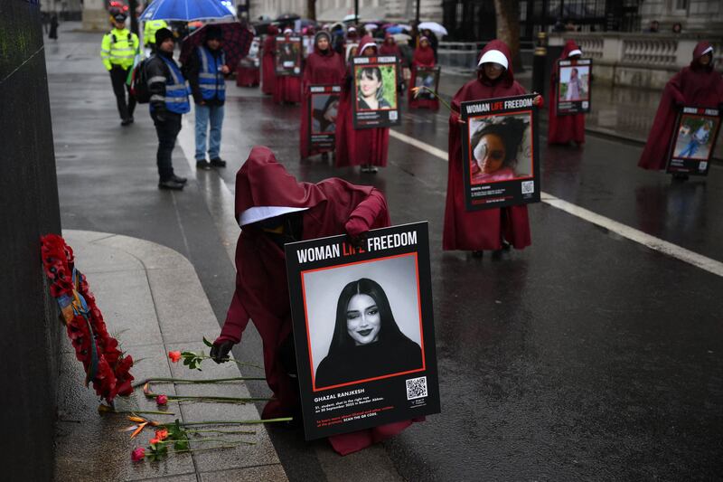 A demonstrator lays red roses at the Monument of the Women of World War II. AFP