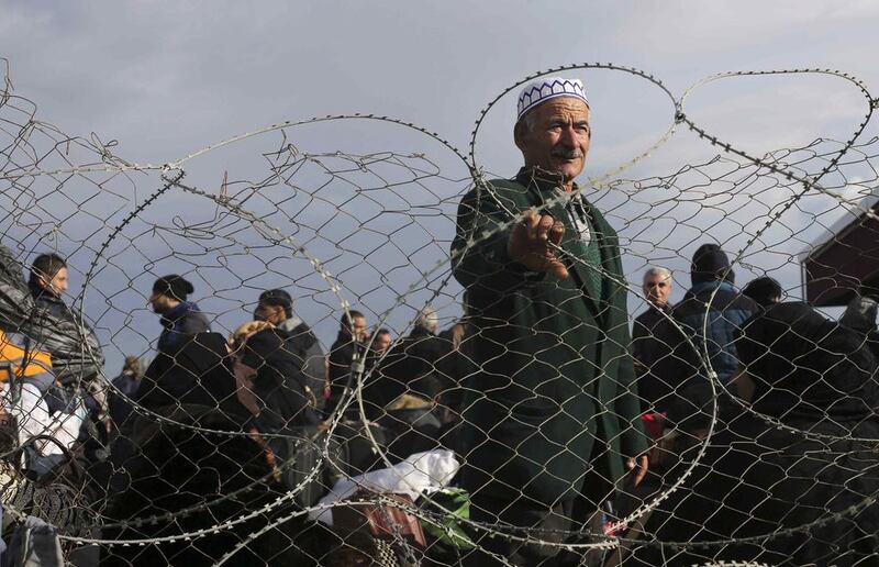 A Palestinian man, hoping to cross into Egypt, stands behind a fence as he waits at the Rafah crossing between Egypt and the southern Gaza Strip. Ibraheem Abu Mustafa / Reuters