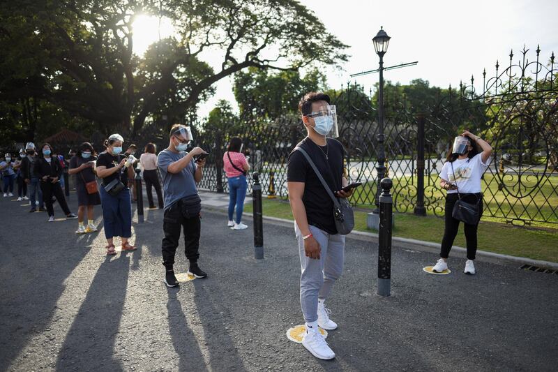 People wearing face masks and face shields as protection from the coronavirus disease (COVID-19) queue outside a newly reopened historical site, in Manila, Philippines. Reuters