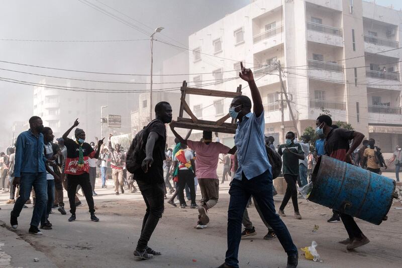 Protesters chant slogans and collect barrels and tables to burn during clashes with police in Dakar on the sidelines of a protest against a last-minute delay to presidential elections in Senegal. AFP