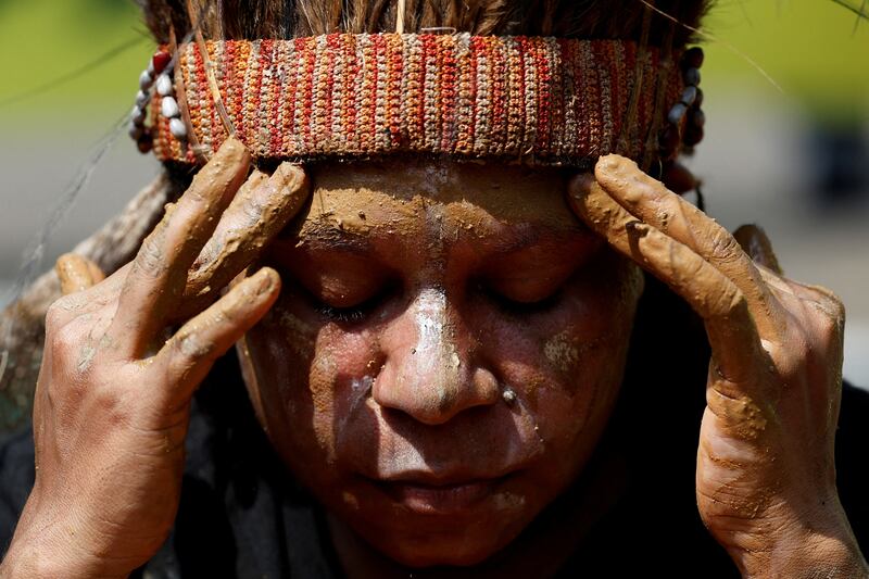 A Papuan activist puts soil on her face as a symbol of grief during a protest against deforestation by palm oil companies on their indigenous land, outside the Supreme Court in Jakarta. Reuters