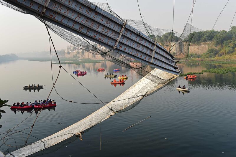 Rescue personnel conduct search operations after a bridge across the river Machchhu collapsed at Morbi in India's Gujarat state. At least 130 people were killed in India after a colonial-era pedestrian bridge collapsed, sending scores of people tumbling into the river below, police said on October 31. AFP