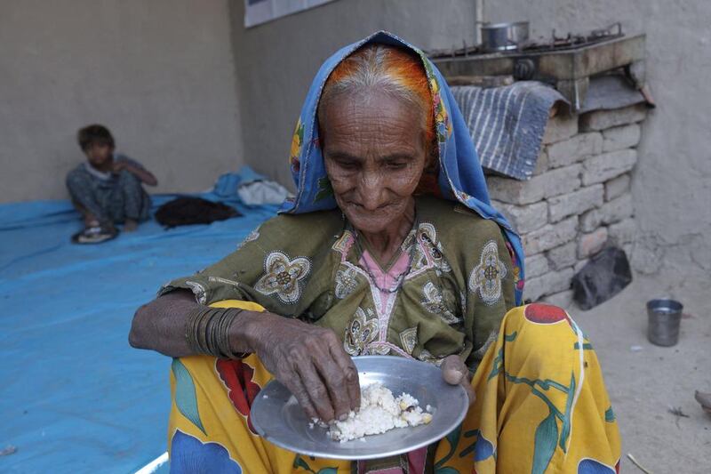 Tulsi, a cotton picker eats her lunch of boiled rice while sitting in her home in Meeran Pur village. Akhtar Soomro / REUTERS