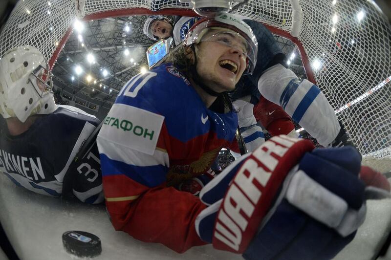 Russia’s Viktor Tikhonov (C) smiles inside the net after he scored past Finland’s goalie Mikko Koskinen (L) and Ville Lajunen (top) during their men’s ice hockey World Championship Group B game at Minsk Arena in Mins. Alexander Nemenov / Reuters