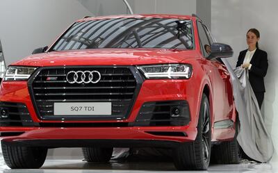 Hostesses unveil a model of Audi's new Q7 SUV car during a presentation at the company's annual press conference in Ingolstadt, southern Germany, on March 3, 2016.  / AFP PHOTO / CHRISTOF STACHE