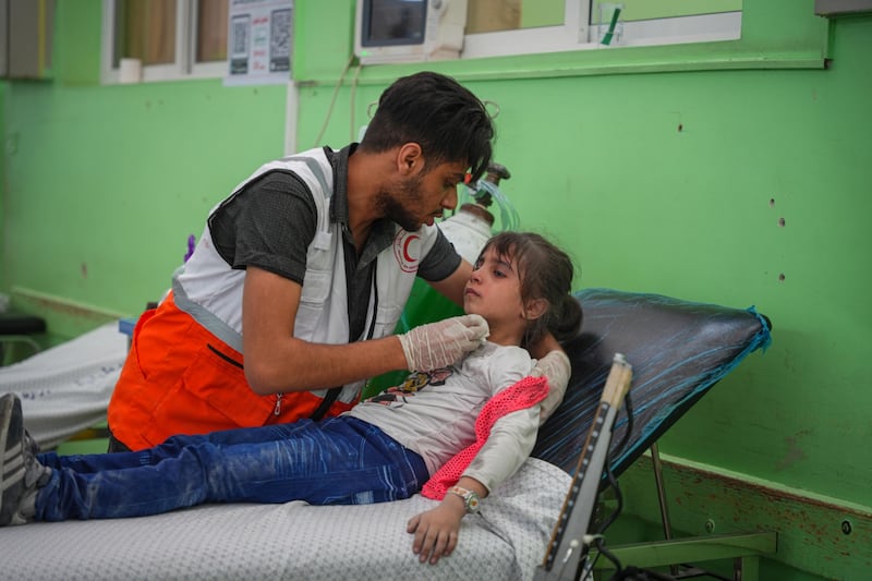 A medic tends to an injured child following Israeli air strikes in the Rimal district of Gaza city. Bloomberg