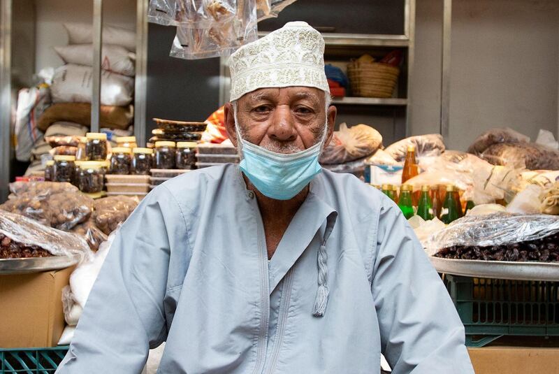 A vendor wearing a face mask against the coronavirus sits in front of his shop at the Mutrah Souq in the Omani capital Muscat.   AFP