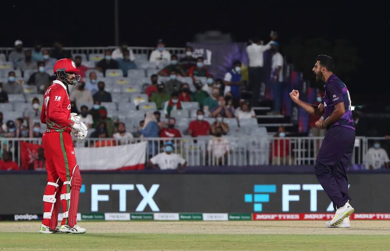 Oman's batsman Kashyap Prajapati, left, watches on as Scotland's bowler Safyaan Sharif celebrates his dismissal. AP