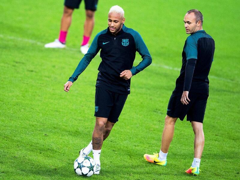 Barcelona players Neymar, left, and Andres Iniesta, right, perform during their team’s training session. Marius Becker / EPA