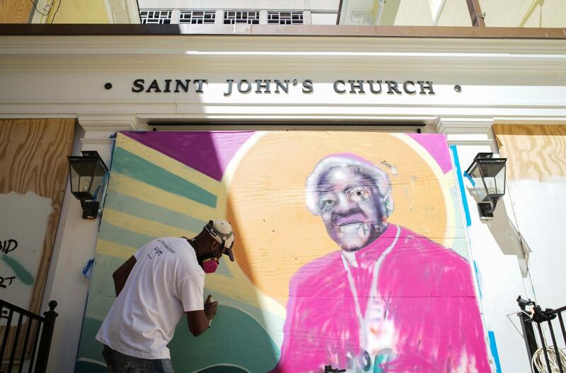 Levi Robinson, curated by Paints Institute, paints a mural of Desmond Tutu on the boarded-up windows of St. John's Church as a work of art activism for racial justice at Black Lives Matter Plaza in Washington, U.S. REUTERS