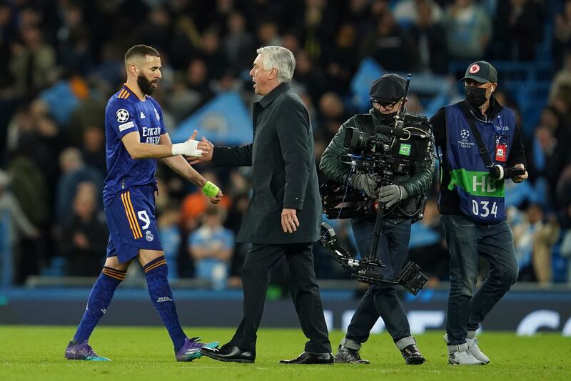 Real Madrid manager Carlo Ancelotti, right, and Karim Benzema shake hands at the end of the match. AP