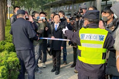 A police officer tries to stop media as a lawyer, center, of Zhang Zhan arrives at a court in Shanghai, China Monday, Dec. 28, 2020. The Pudong New Area People��������s Court sentenced Zhang, a former lawyer who reported on the early stage of the coronavirus outbreak to four years in prison on charges of �������picking fights and provoking trouble," one of her lawyers said. (Kyodo News via AP)