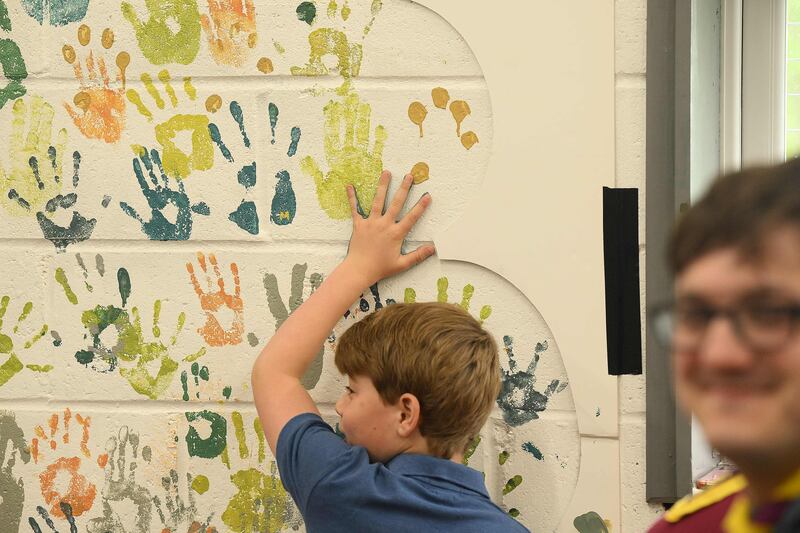 Prince George tries out some hand-painting at the 3rd Upton Scouts' hut in Slough, where the royals joined volunteers helping to renovate and improve the building. AFP