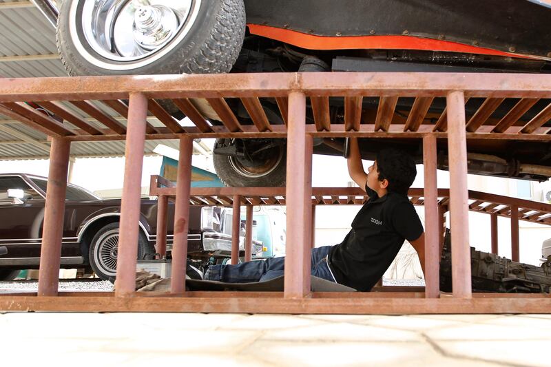 Sharjah, May 9, 2013 - Khalid Mubarak, 14, gets his hands dirty while fixing a car at his family's classic car "garage" in Sharjah, May 9, 2013.(Photo by: Sarah Dea/The National)

