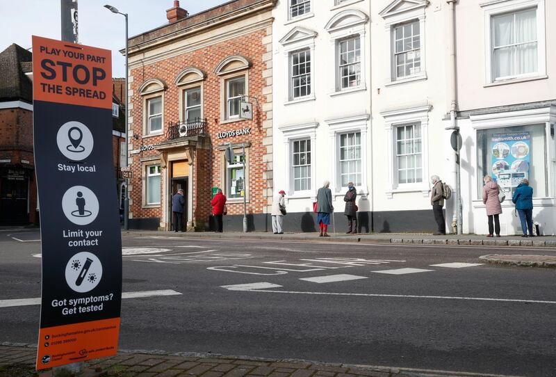 People social distance outside a bank in Buckingham. Reuters