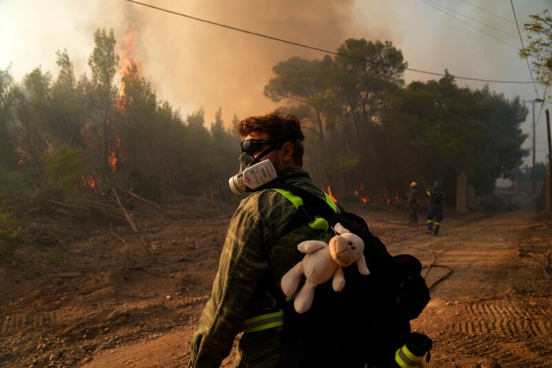A volunteer helps tackle a wildfire in the village of Siderina, south of Athens.