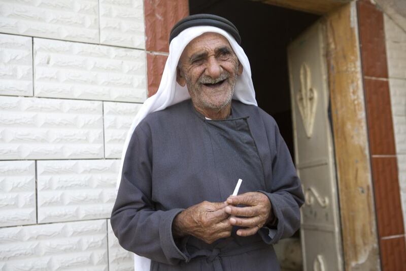 Hussein Atatarah stands holding a cigarette he rolled in the courtyard of the family’s home in Zbouba.