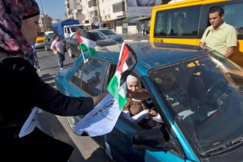 epa02914993 Activists of the Palestine 194 campaign distribute flags and leaflets to motorists in order to drum for Palestine to become the 194th state recognised by the UN, in the West bank town of Ramallah, on 13 September 2011. The United States has already said it would veto such a request for Palestinian statehood if it comes before a vote in the UN Security Council later this September. Israel is also opposed, although the Palestine 194 campaign claims has the support of 125 countries - more than a majority of world states.  EPA/ATEF SAFADI *** Local Caption ***  02914993.jpg