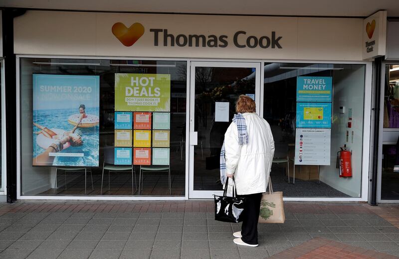FILE PHOTO: A woman stands outside a closed Thomas Cook travel agents store near Manchester, Britain, October 9, 2019. REUTERS/Phil Noble/File Photo