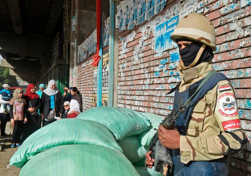 An Egyptian army conscipt stands guard as voters queue up outside a polling station before the start of the first day of the 2018 presidential elections, in Boulaq al-Dakrour neighbourhood in the capital Cairo's southwestern Giza district on March 26, 2018. Khaled Desouki / AFP