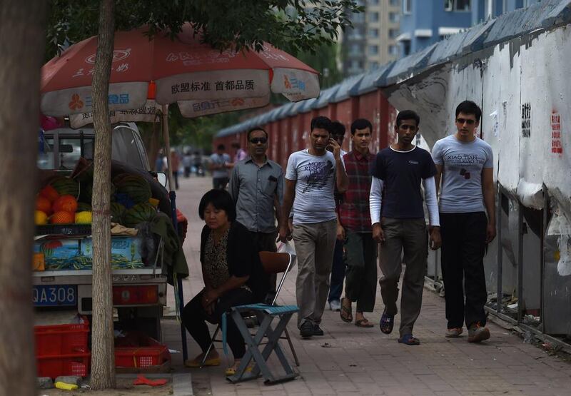 Pakistani refugees and asylum seekers (from left) Mahdi, Waheed Ahmad, Yasir Chaudry (obscured), Sarim, Asif Mangla and Moeed walk down a street in Sanhe, China’s Hebei province. They are members of a minority sect in Pakistan that have fled discrimination and violence and found unlikely refuge in China. Greg Baker/AFP Photo