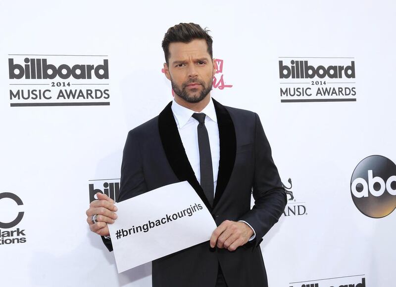 Musician Ricky Martin arrives at the 2014 Billboard Music Awards in Las Vegas, Nevada on May 18, 2014 holding up a sign referring to the girls kidnapped in Nigeria. L.E. Baskow / Reuters