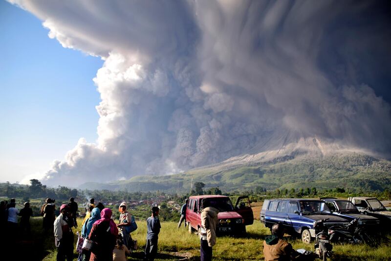 A crowd gathers to watch after the eruption of Mount Sinabung in Karo, North Sumatra. AP