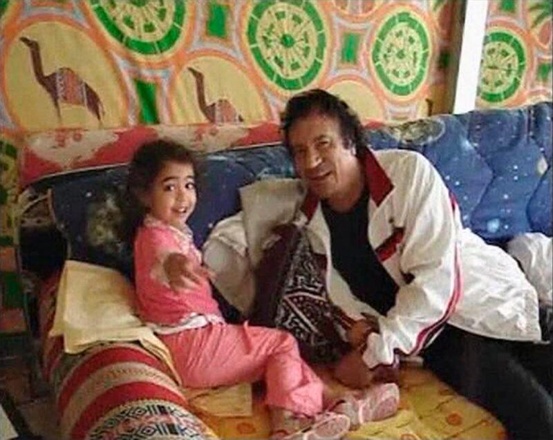 Muammar Gaddafi relaxes with his granddaughter in his tent at the Bab al-Aziziya compound in Tripoli in this file photo of a still image taken from an exclusive amateur video from 2005 obtained by Reuters on September 7, 2011. Gaddafi died of wounds suffered in his capture near his hometown of Sirte on October 20, 2011, a senior NTC military official said. National Transitional Council official Abdel Majid Mlegta told Reuters earlier that Gaddafi was captured and wounded in both legs at dawn on Thursday as he tried to flee in a convoy which NATO warplanes attacked.  REUTERS/Reuters TV/Files (LIBYA - Tags: POLITICS) *** Local Caption ***  SIN306_LIBYA-_1020_11.JPG