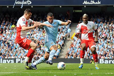 epa03217457 Manchester City's Carlos Tevez (C) vies for the ball with Queens Park Rangers Joey Barton (L) and Djibril Cisse (R) during the English Premier League soccer match at Etihad Stadium in Manchester, Britain, 13 May 2012.  EPA/PETER POWELL DataCo terms and conditions apply. http//www.epa.eu/downloads/DataCo-TCs.pdf