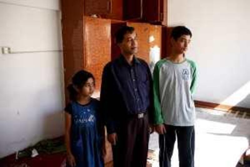 March 17, 2010 / Abu Dhabi / (Rich-Joseph Facun / The National) From left, Shaima Hussain (CQ), 7, her father Gulzar Hussain (CQ), and her brother Humayun (CQ), 12, visit the villa that was their home for ten years, Wednesday, March 17, 2010 in Abu Dhabi. The villa is now covered in rubble, lacks windows and is slated for demolition 