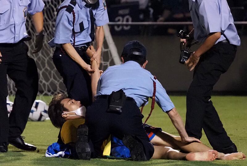 Security officers pin down a pitch invader in Tokyo. AFP